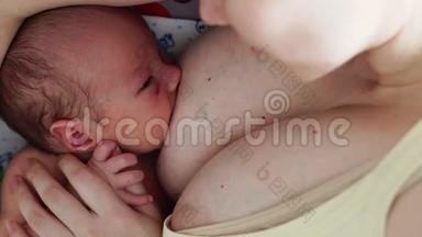 一位年轻妇女在家给她的小宝宝喂奶，特写。